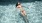 woman floats on her back in swimming pool