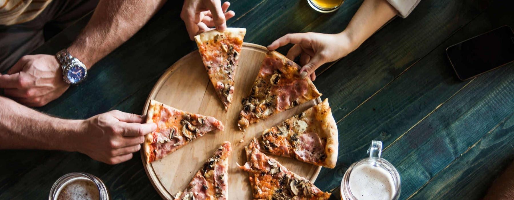 a group of people eating pizza